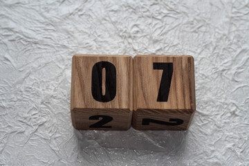 Wooden cubes with numbers on a white crumpled background. 07