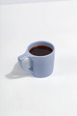 blue cup with black coffee on a white background