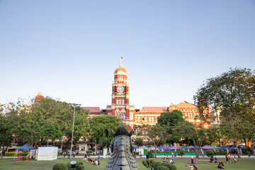 Fototapeta premium Queen Anne–style former High Court at the east side of Mahabandoola Garden, Yangon, Burma (Myanmar), with its bell clock tower and rooftop lion statues designed by James Ransome