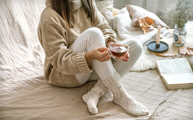 Cozy autumn or winter at home, a woman in a knitted sweater