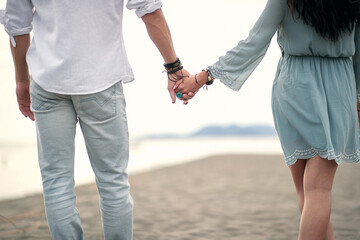  Couple holding hands.Romantic  walk by the sea.
