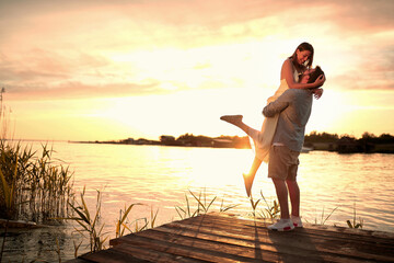 Enjoying By The River.Romantic couple in love dating at sunset at river.