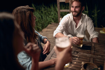 Couple enjoying at evening fun and drinks beer.