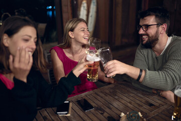 Man and woman enjoying at evening fun and drinks beer.Friends enjoying drinks together.