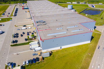 Aerial view of goods warehouse. Logistics center in industrial city zone from above. Aerial view of trucks loading at logistic center