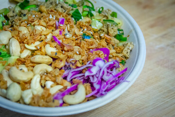 Vegan poke bowl with cashew nuts, red cabbage, dried onions, avocado and much more ingredients