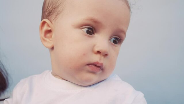 portrait newborn baby boy close-up a blurred background. kid baby smiling little boy. childhood dream concept. kid portrait close-up on lifestyle blue background. newborn child dream