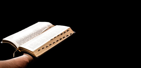 A man holds an open Bible. The concept of a relationship with God.
