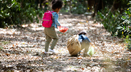 Summer camp. little cute  girl catching butterflies and bugs with her scoop-net. Asian and american african girl catch insects in the forest on advanture camping travel trip