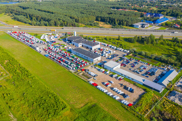 Lots of freight trailers. Cars are in several rows. Truck parking. Aerial view vertically down.