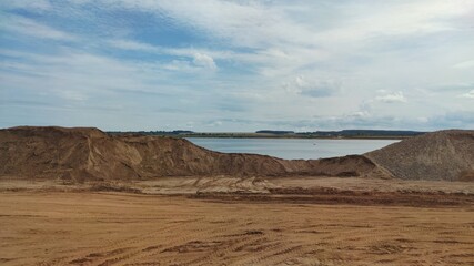 sand quarry on the river bank against the background of a beautiful blue sky