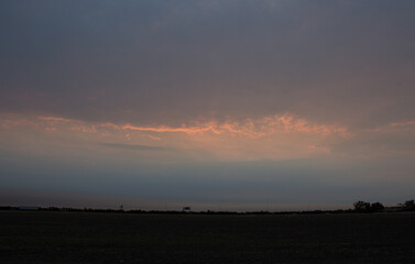 sunrise in a row of clouds 