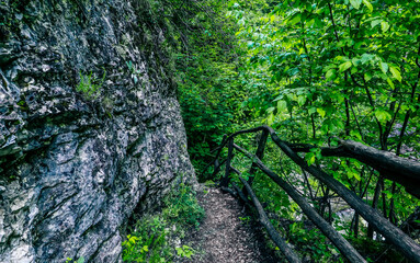 Wooden stairway in the mountain, dangerous place. Extreme travelling at the mossy forest. Pathway in a rock rift.