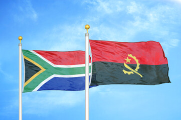 South Africa and Angola two flags on flagpoles and blue sky