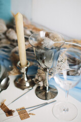 Festive table setting in blue colors. Wine glasses close-up. Bengal lights. Soft focus. Film grain.
