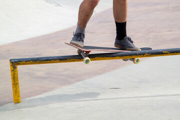Fototapeta na wymiar rider on skateboard slides along edge of metal ramp in skate park