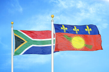 South Africa and Guadeloupe two flags on flagpoles and blue sky