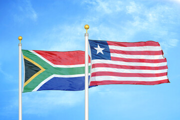 South Africa and Liberia two flags on flagpoles and blue sky