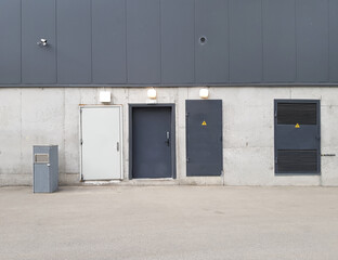 three doors on a concrete wall, technical or fire exit, loading area, building facade