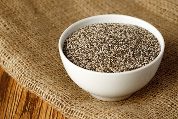 Bowl with raw chia seeds close up
