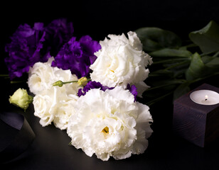 Funeral flowers of white and purple eustoma on a black background