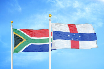 South Africa and Netherlands Antilles two flags on flagpoles and blue sky