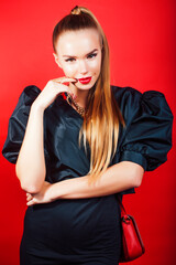 young pretty woman young lady posing on red background wearing gold jewelry, lifestyle people concept