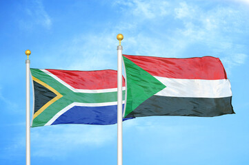 South Africa and Sudan two flags on flagpoles and blue sky