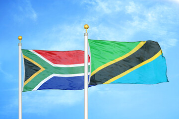 South Africa and Tanzania two flags on flagpoles and blue sky