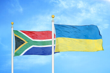 South Africa and Ukraine two flags on flagpoles and blue sky