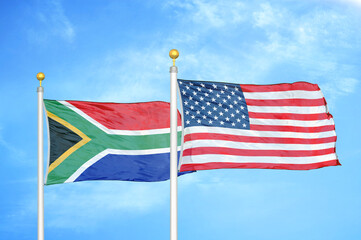 South Africa and United States two flags on flagpoles and blue sky