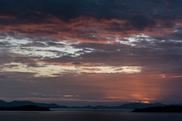 sea, sky with dramatic clouds at golden sunset in phuket  