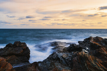 Seaside rocks, Waves hitting the rocks by the sea against the sunset.