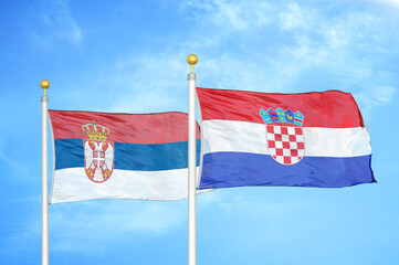 Serbia and Croatia two flags on flagpoles and blue sky