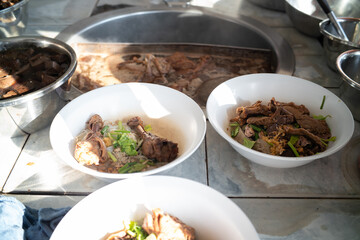 Chef hand cooking hot boiled soup noodle with duck meat in local traditional restaurant
