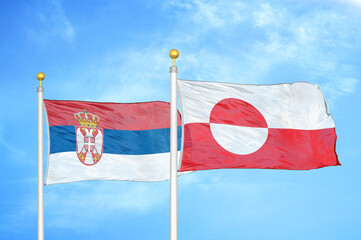 Serbia and Greenland two flags on flagpoles and blue sky