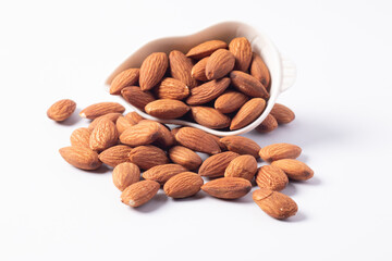 Almonds in a white ceramic cup on a white background