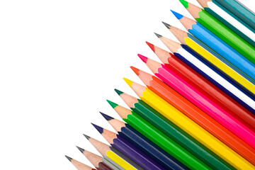 Line of different color wood pencil crayons placed on a white background