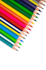 row of different color wood pencil crayons placed on a white background