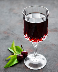 Cherry liqueur in a glass and fresh fruits