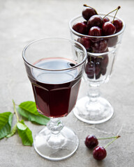Cherry liqueur in a glass and fresh fruits