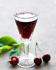 Cherry liqueur in a glass and fresh fruits
