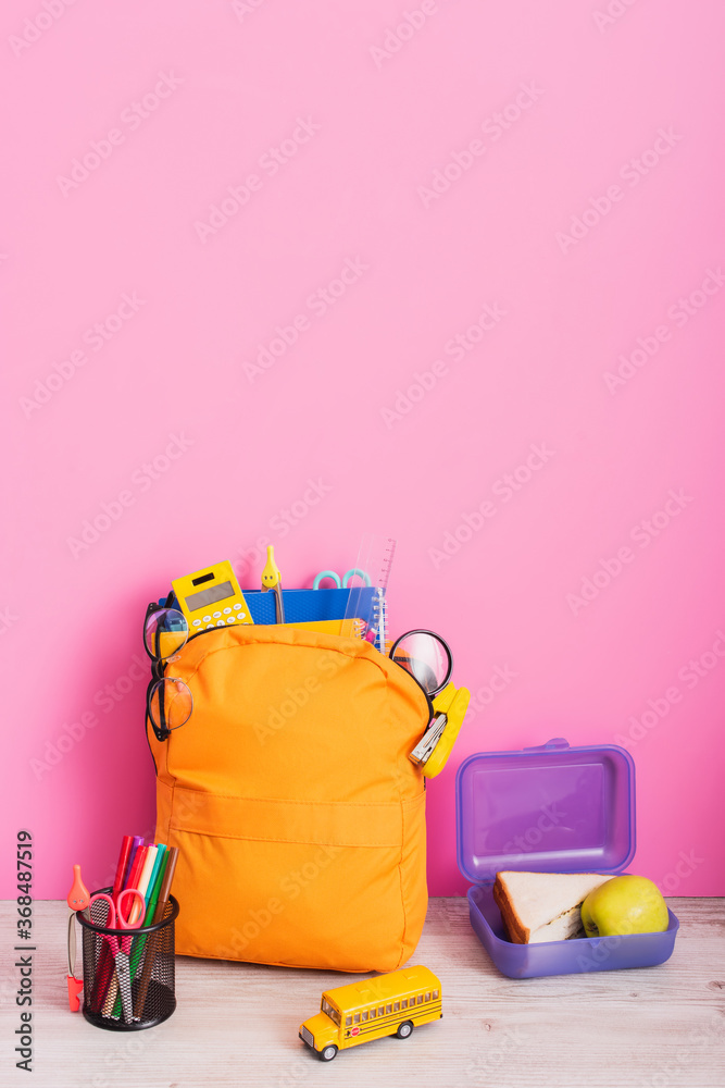 Canvas Prints yellow backpack with school supplies near lunch box, school bus model and pen holder with felt pens 