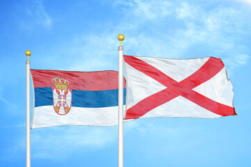 Serbia and Northern Ireland two flags on flagpoles and blue sky