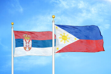 Serbia and Philippines two flags on flagpoles and blue sky