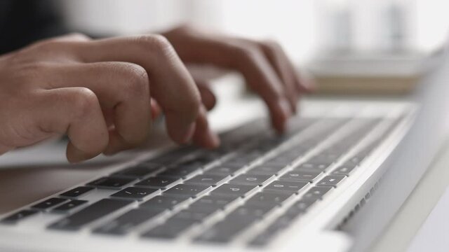 Male student in uniform has his finger pressed on the keyboard to email a report in his office at home, Working at home or studying at home concept. 