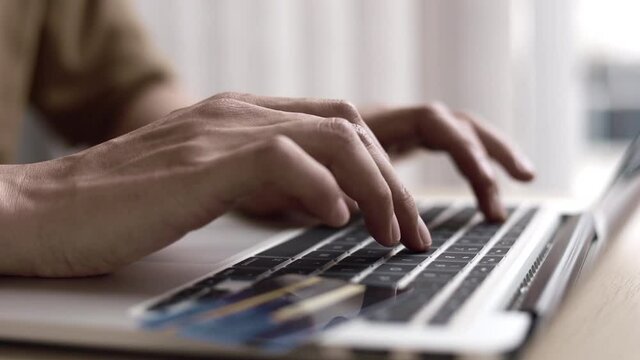 Male student in uniform has his finger pressed on the keyboard to email a report in his office at home, Working at home or studying at home concept. 