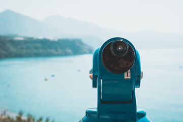 Blue binoculars looking out onto a beach