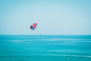 Paraglider flying through the blue sky