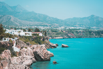 Obraz premium Houses on a cliff by the sea and the mountain in the background